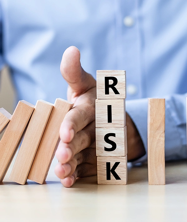 Hand stopping a domino chain to prevent risk from cascading through a business